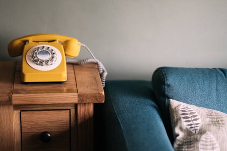 Yellow phone next to blue sofa